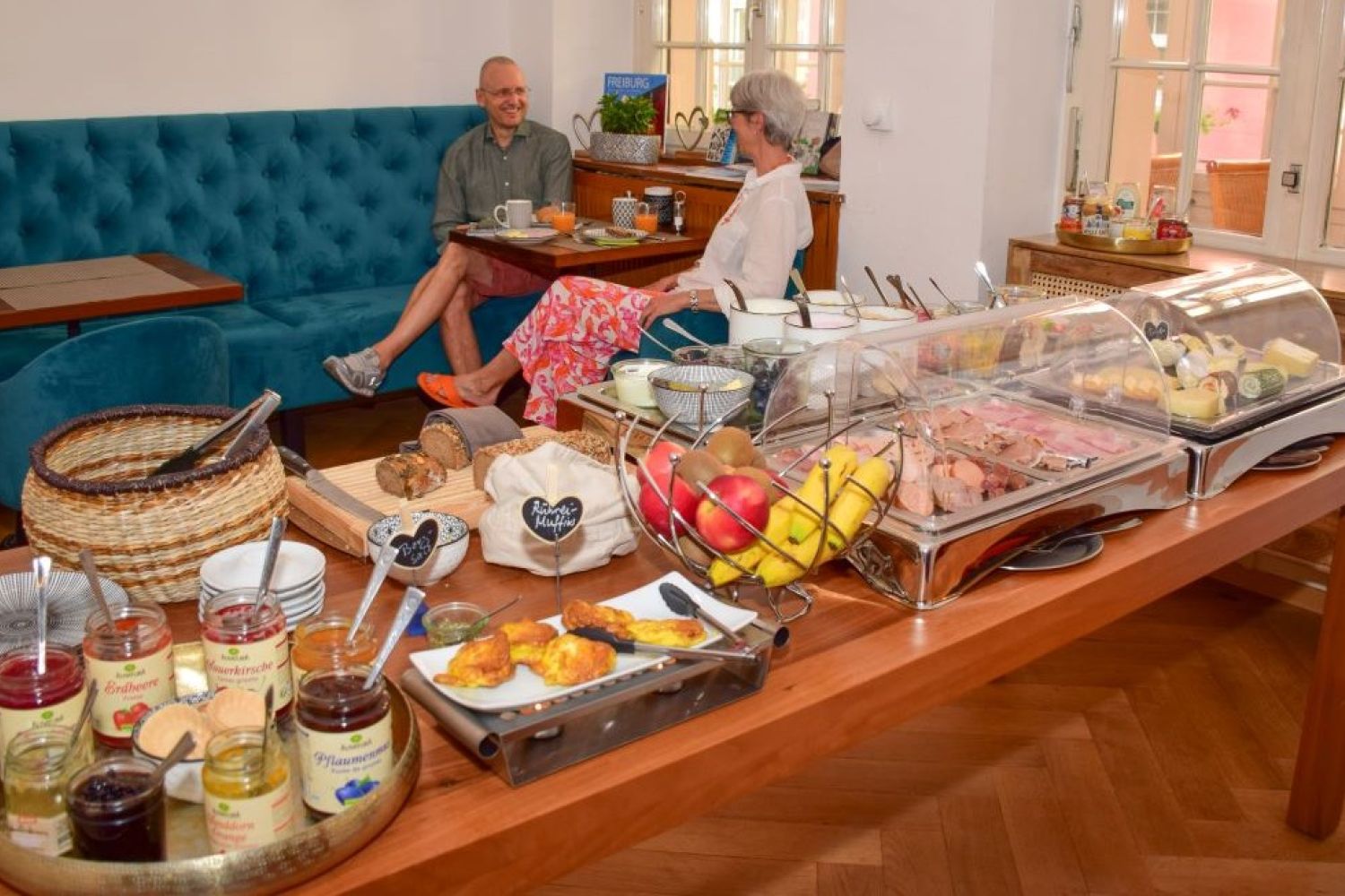 Bio-Frühstücksbuffet mit frischem Obst, Eiern, Pancakes, Aufschnitt, Käse, Aufstrichen und Brot